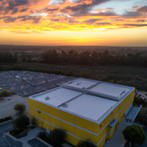 An aerial view of a data storage server building with a bright yellow sky.