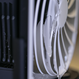 Close up of a computer fan with a stream of water pouring over it.